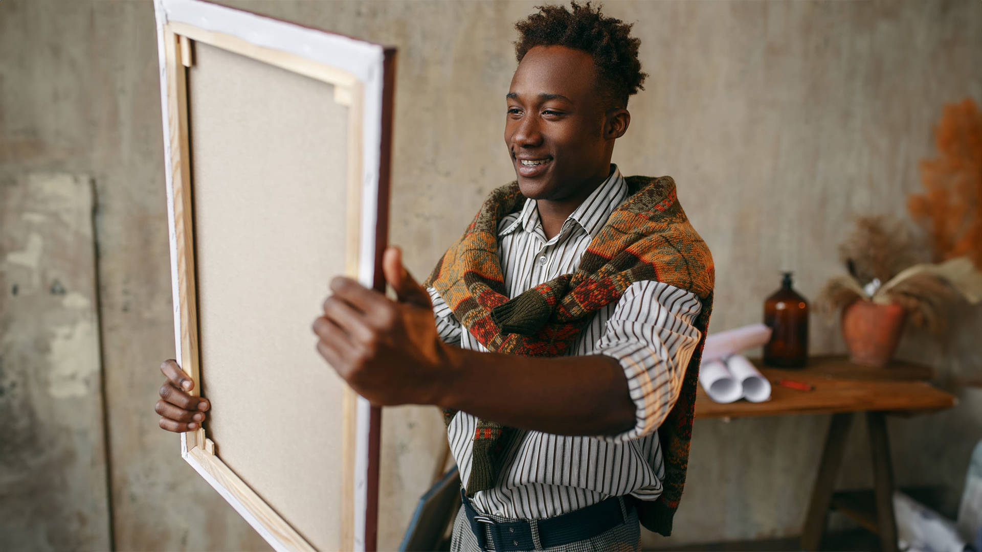 A smiling customer holding a blank canvas, showcasing the premium quality and hand-stretched finish of our Custom Canvas Printing.